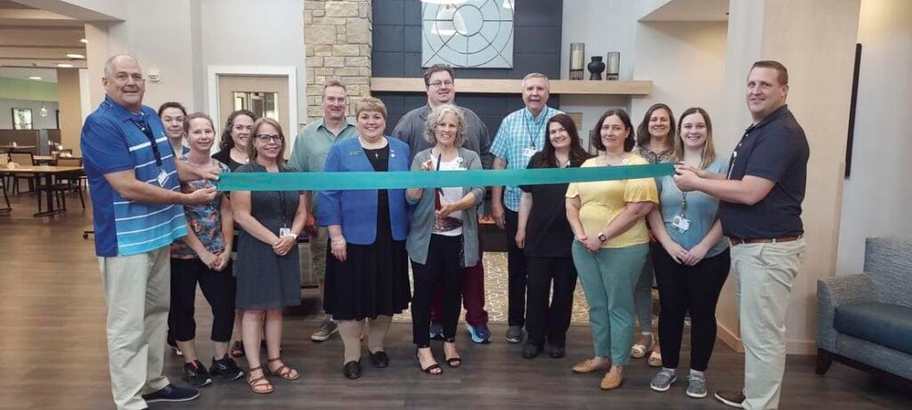 Group of WHCC members cutting a ribbon at Haven Homes Senior Living.